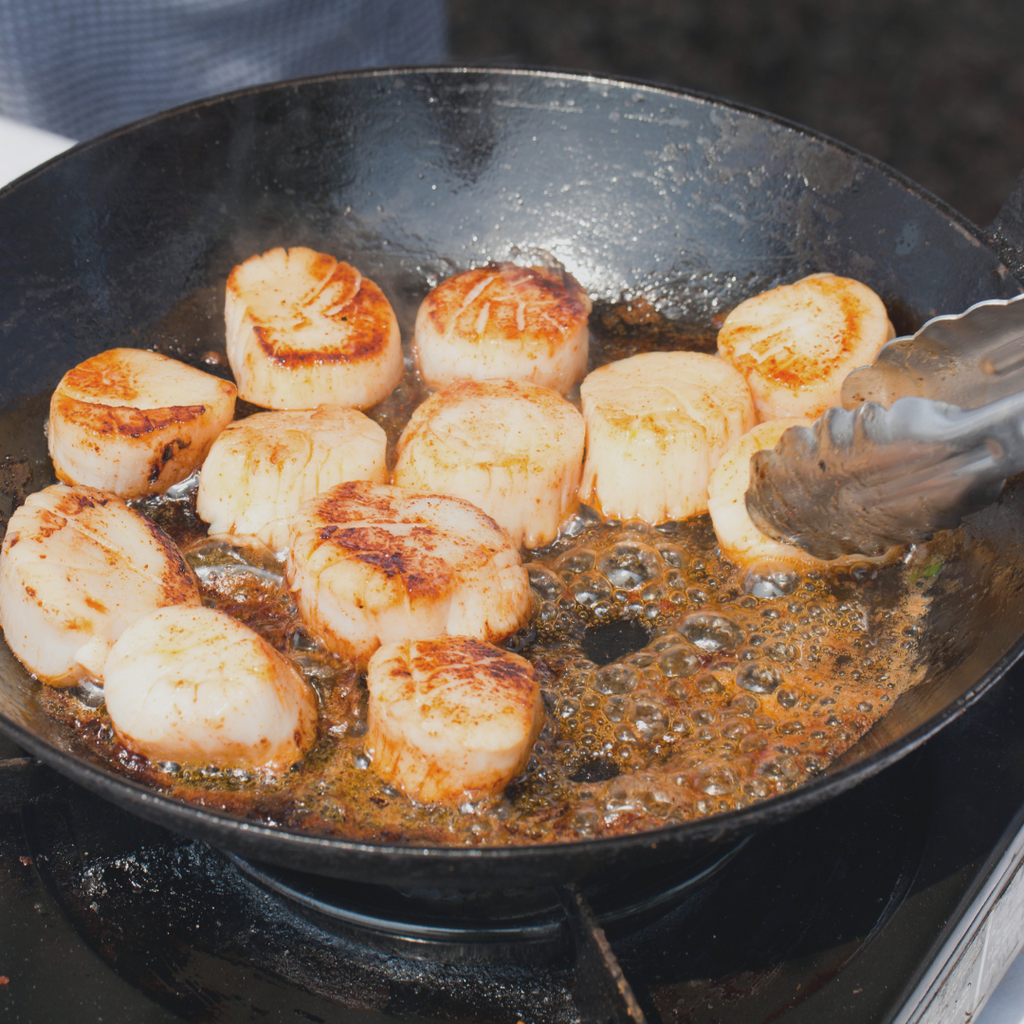 image of scallops being cooked in a wok with butter