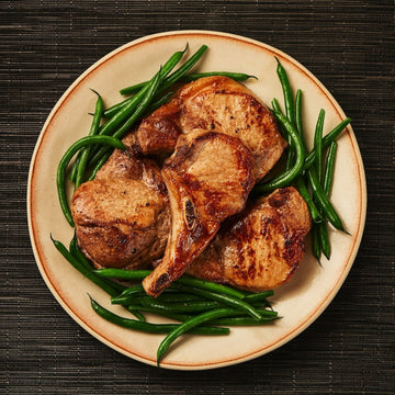 image of cooked pork chops on a platter with green beans