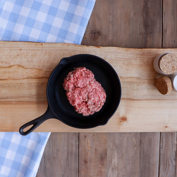 image of chub of ground beef on a cast iron pan on a table 